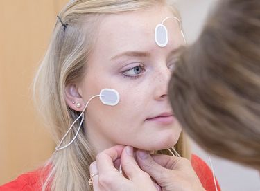 Das Bild zeigt die Verkabelung einer Patienten mit Elektroden am Kopf und-Stirnbereich