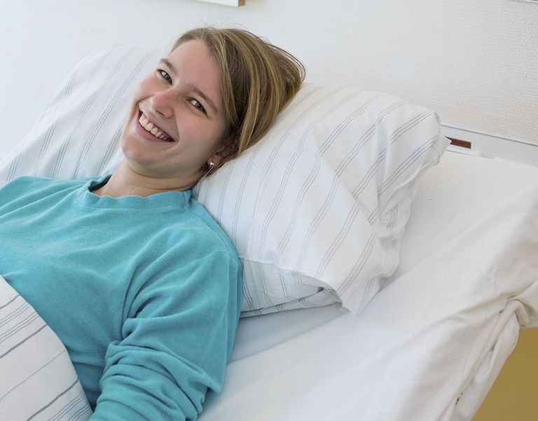 Das Bild zeigt eine Patientin auf dem Krankenbett.