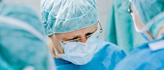 Das Bild zeigt einen Chirurgen bei einer Operation