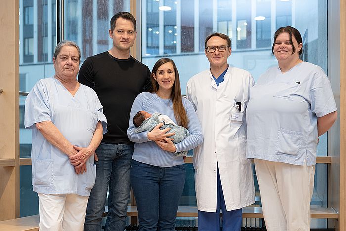 Das Bild zeigt Familie Wegner mit Klinikdirektor Professor Dr. Andreas Müller und Pflegefachkräften auf der Station S22.